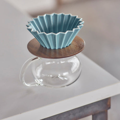 Blue ceramic filter on a wooden stand with a glass base on a blurred background
