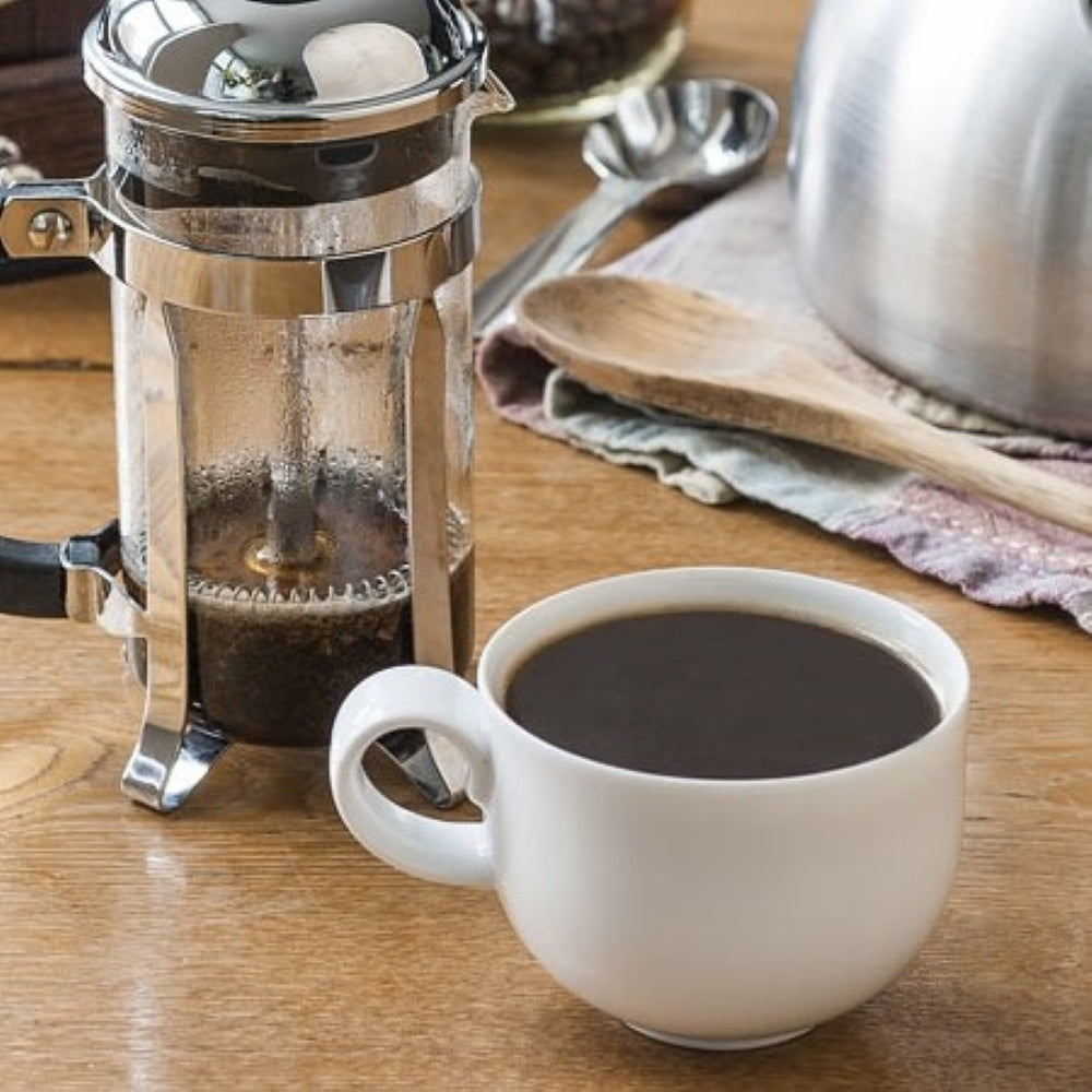 French press coffee with a cup of coffee on a wooden table