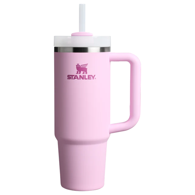 A light pink Stanley tumbler with a matching pink handle, a white lid, and a white straw, shown on a plain white background.