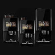 Three black coffee machines with digital displays on a black background