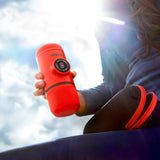 Person holding a red coffee mug with a blurred background