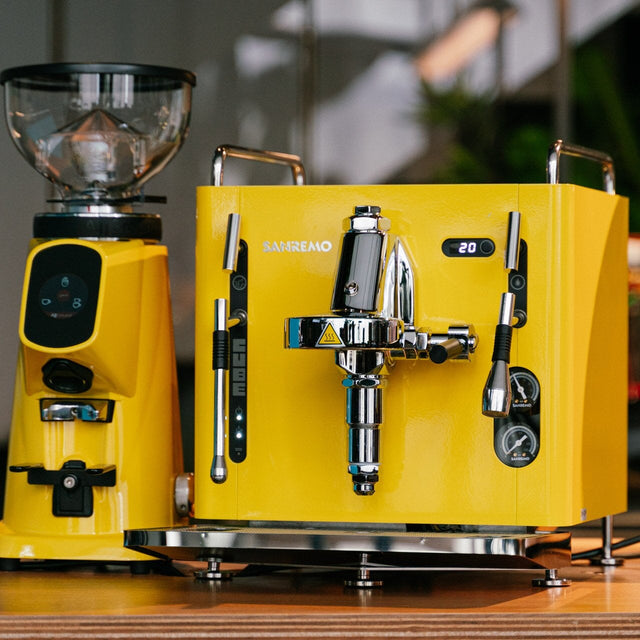 Yellow coffee machine on a wooden surface with a blurred background