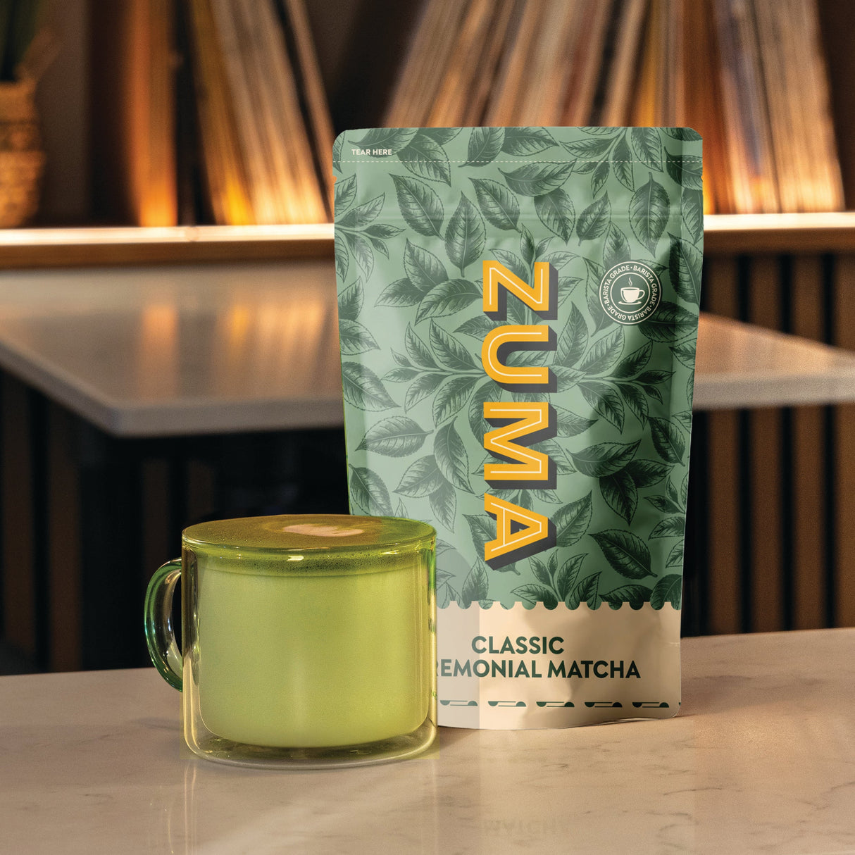 Zuma matcha packaging with a green mug on a wooden surface