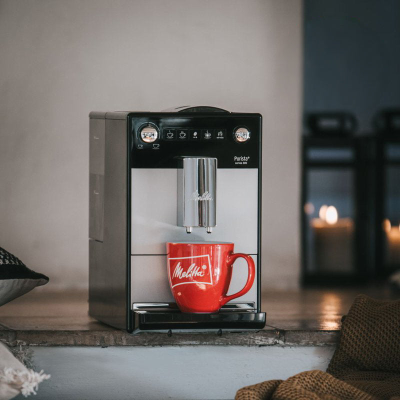 Espresso machine with a red mug on a wooden surface