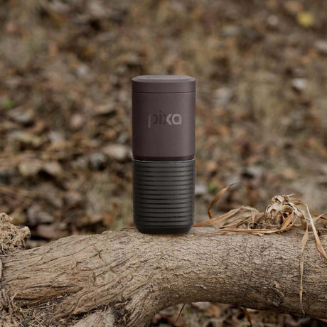Dark Burgundy Wacaco Pixapresso standing on a fallen branch in woodland